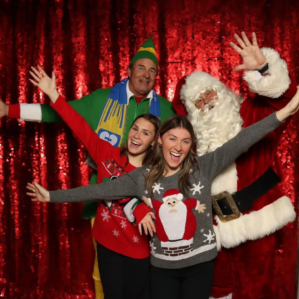 A team of colleagues laughing together at a Kansas City corporate holiday event.