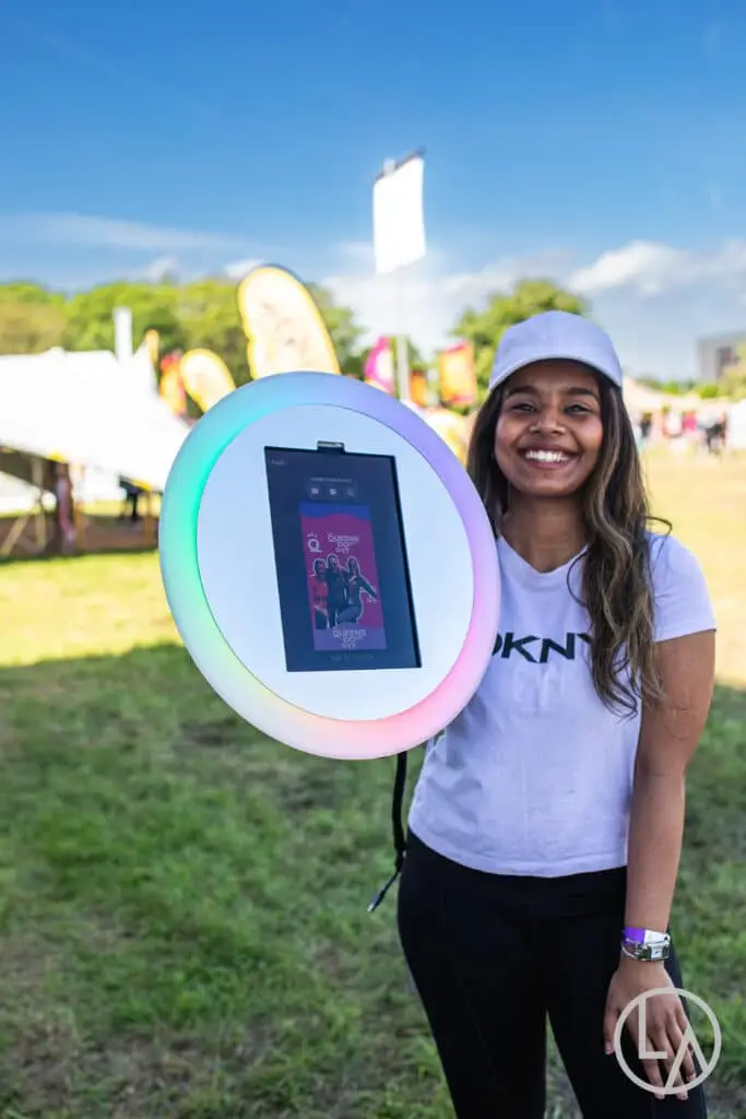 Roaming photo booth attendant photographing guests at an outdoor corporate event in Kansas City