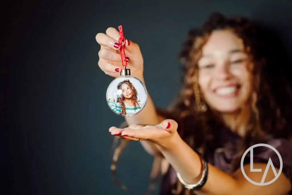 Delighted corporate guest holding her personalized Holiday Bauble keepsake in Kansas City