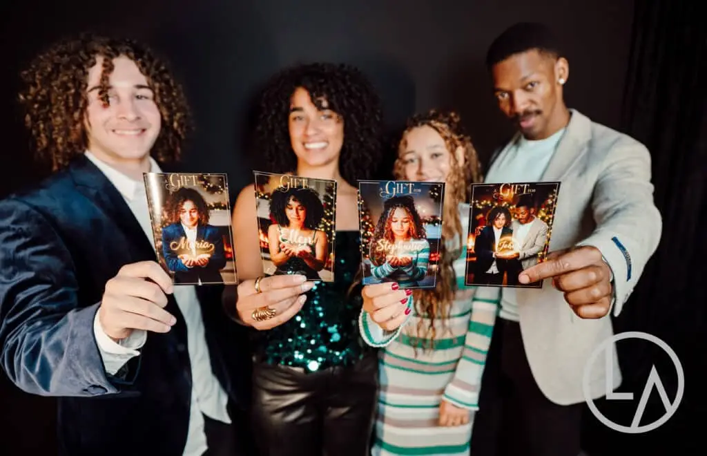 Corporate guests holding personalized printed keepsakes from The Gift holiday experience in Kansas City